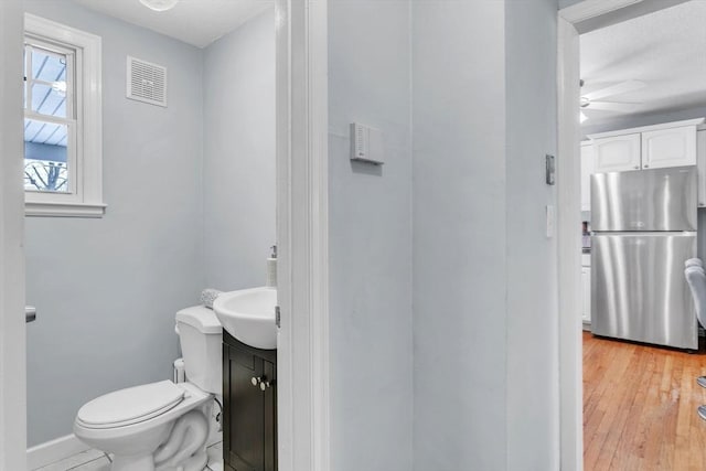 bathroom with vanity, ceiling fan, hardwood / wood-style flooring, and toilet