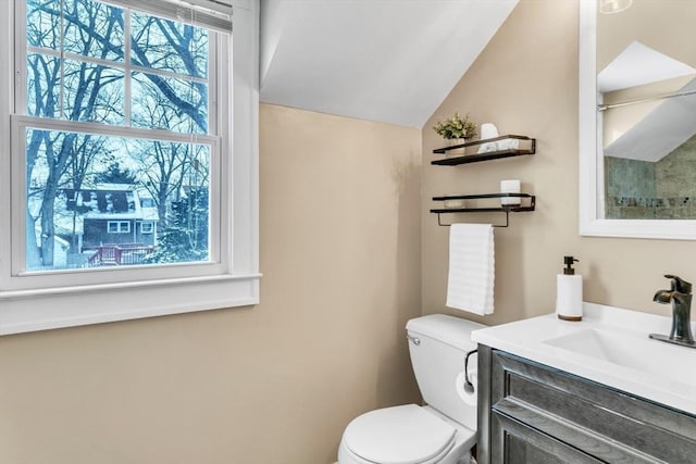 bathroom featuring vanity, toilet, and vaulted ceiling