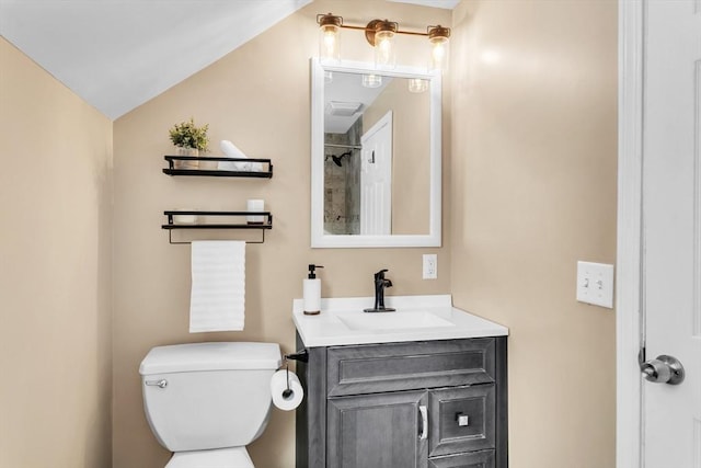 bathroom featuring vanity, vaulted ceiling, and toilet