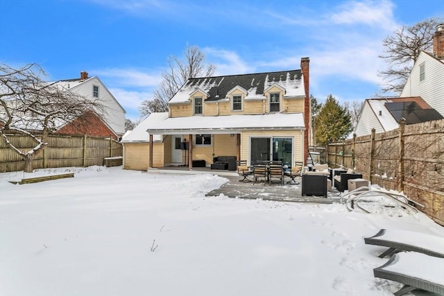 snow covered back of property with outdoor lounge area