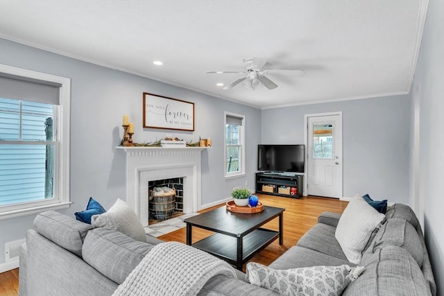 living room featuring light hardwood / wood-style flooring, ornamental molding, and ceiling fan