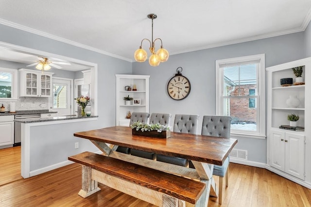 dining room with crown molding, ceiling fan with notable chandelier, and light hardwood / wood-style floors