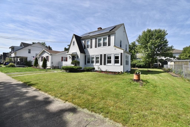 98 Osborne Ter, Springfield, MA 01104 - view of front facade featuring a chimney, solar panels, and a residential view