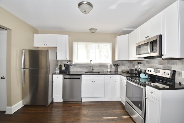 98 Osborne Ter, Springfield, MA 01104 - kitchen with stainless steel appliances, a sink, dark countertops, tasteful backsplash, and dark wood finished floors