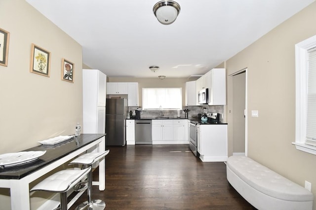 98 Osborne Ter, Springfield, MA 01104 - kitchen featuring appliances with stainless steel finishes, a sink, dark countertops, tasteful backsplash, and dark wood-style flooring