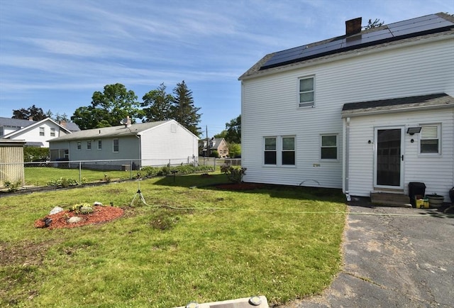98 Osborne Ter, Springfield, MA 01104 - back of property with entry steps, solar panels, and a chimney