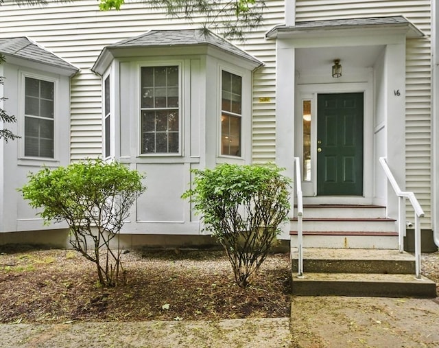 property entrance featuring roof with shingles