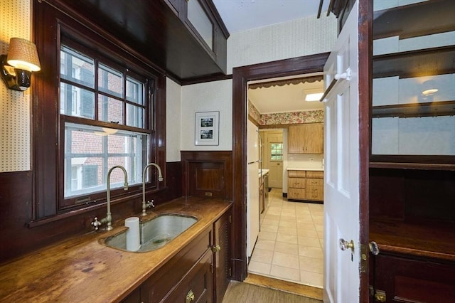 92 Dean Rd, Brookline, MA 02445 - kitchen featuring wallpapered walls, a sink, and light tile patterned floors