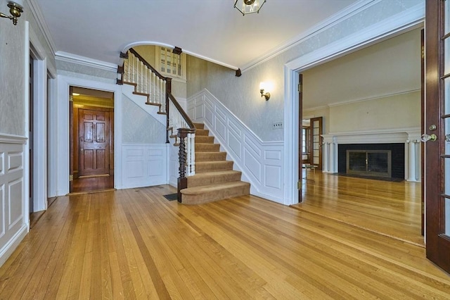 92 Dean Rd, Brookline, MA 02445 - foyer featuring a decorative wall, stairway, light wood-type flooring, ornamental molding, and wainscoting