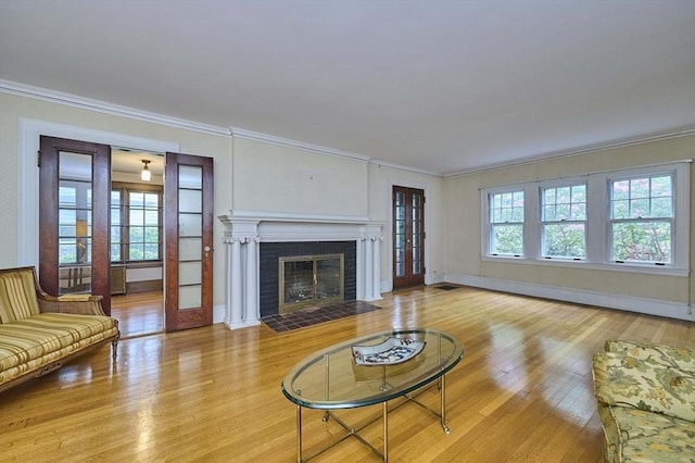 92 Dean Rd, Brookline, MA 02445 - living room with wood finished floors, a baseboard radiator, crown molding, a fireplace, and baseboards