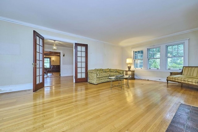 92 Dean Rd, Brookline, MA 02445 - unfurnished living room featuring french doors, light wood finished floors, crown molding, and a wainscoted wall