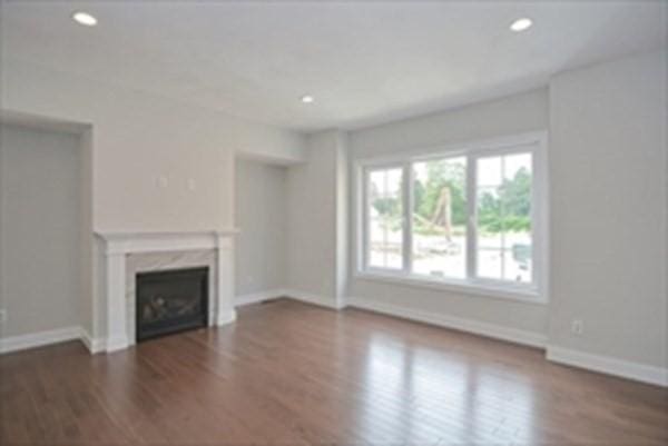 unfurnished living room with dark hardwood / wood-style floors and a high end fireplace