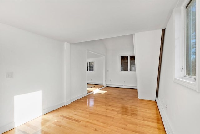 spare room with wood-type flooring and a baseboard radiator