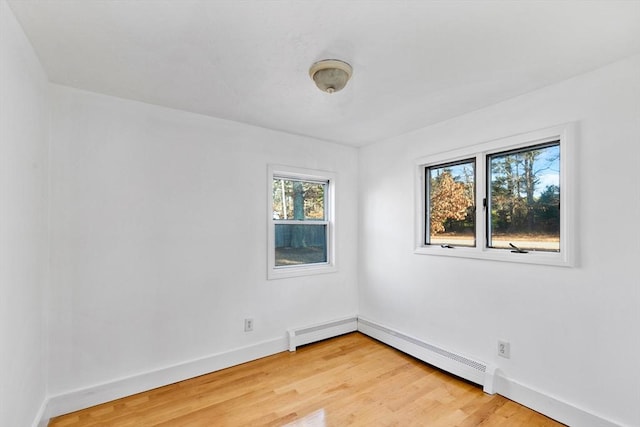 empty room with hardwood / wood-style floors and baseboard heating