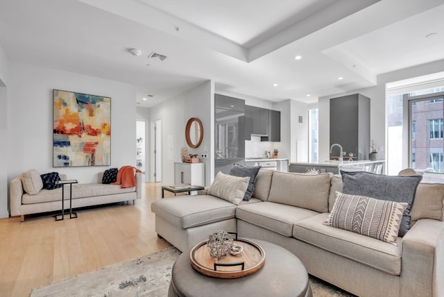 living room with light hardwood / wood-style flooring and sink