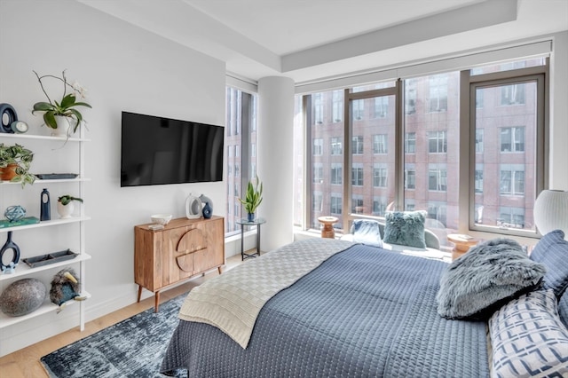 bedroom featuring multiple windows and hardwood / wood-style flooring