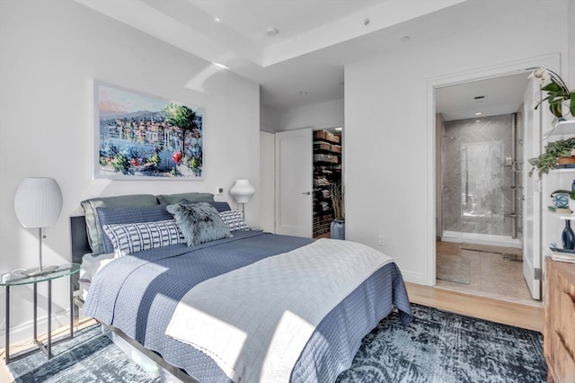 bedroom featuring hardwood / wood-style flooring, connected bathroom, and a closet