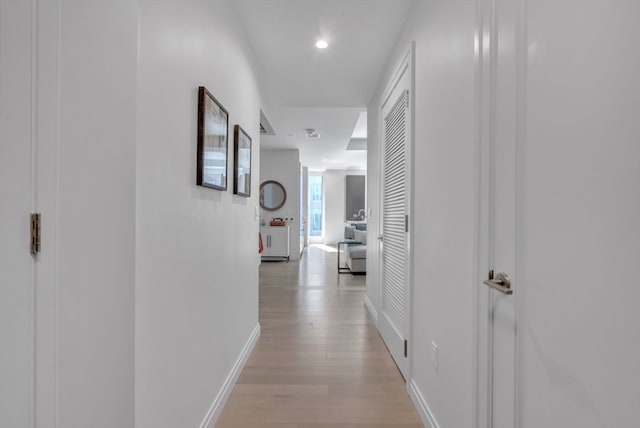 hallway with light hardwood / wood-style floors