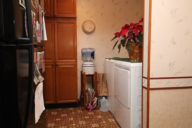 clothes washing area featuring separate washer and dryer and cabinets