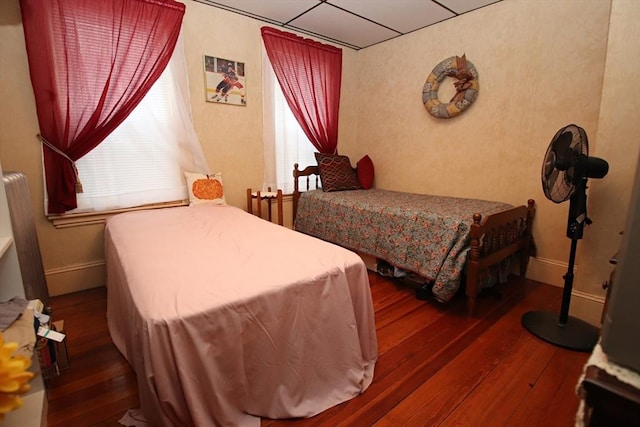 bedroom featuring dark hardwood / wood-style flooring and a drop ceiling