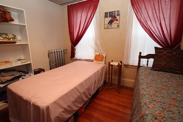 bedroom featuring radiator and hardwood / wood-style floors