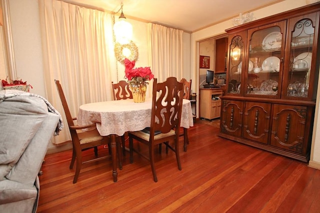 dining space with hardwood / wood-style floors and ornamental molding