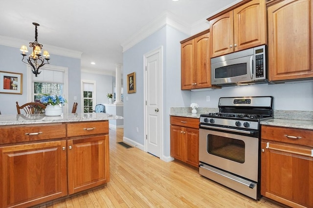 kitchen with visible vents, light stone countertops, appliances with stainless steel finishes, and light wood-style flooring