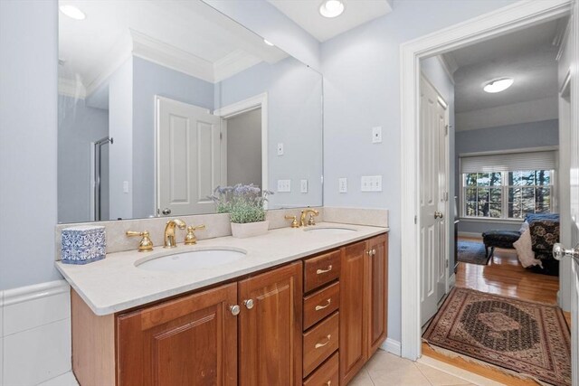 bathroom with ensuite bath, double vanity, tile patterned floors, and a sink