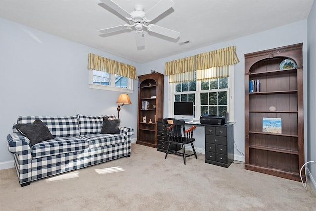 carpeted home office with visible vents, baseboards, and a ceiling fan