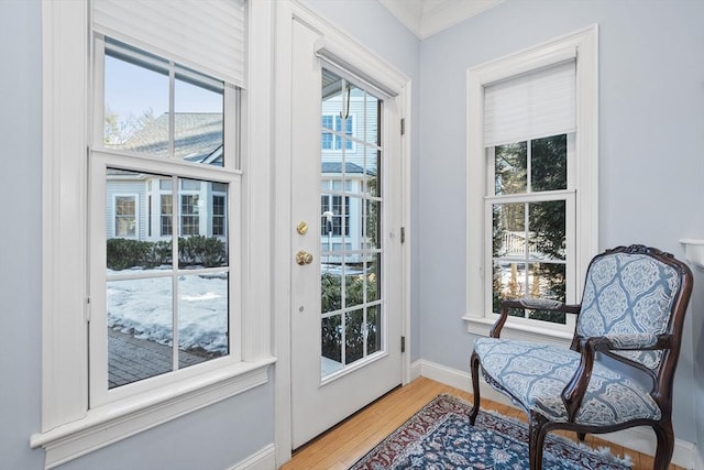 doorway to outside featuring light wood finished floors and baseboards