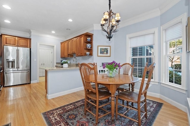 dining room featuring baseboards, ornamental molding, recessed lighting, light wood-style flooring, and an inviting chandelier