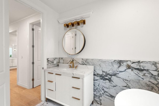 57 Mayflower Rd, Needham, MA 02492 - bathroom with vanity, wood finished floors, ornamental molding, and backsplash