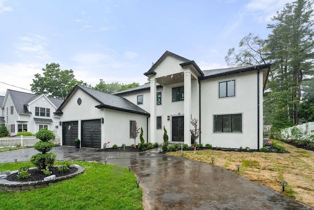 57 Mayflower Rd, Needham, MA 02492 - view of front of house with stucco siding, an attached garage, and asphalt driveway