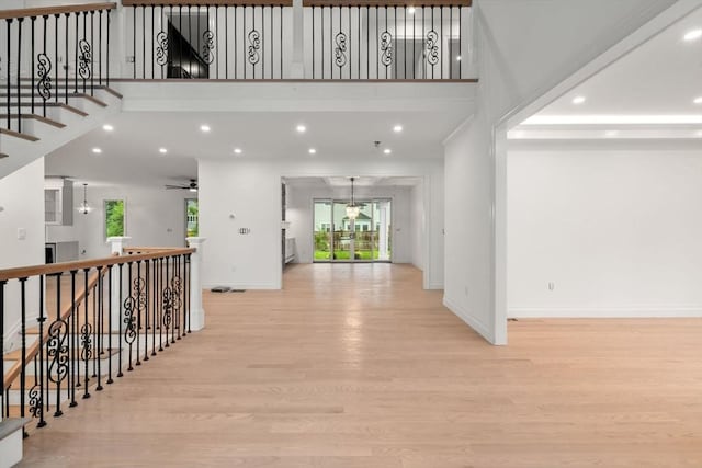 57 Mayflower Rd, Needham, MA 02492 - hall with light wood-style flooring, baseboards, a high ceiling, and recessed lighting