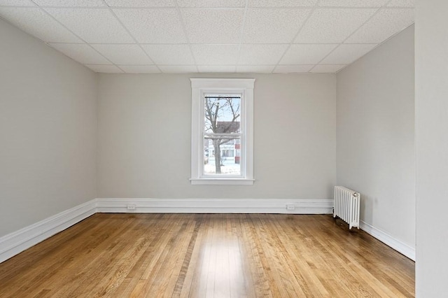 empty room featuring light wood-type flooring and radiator heating unit