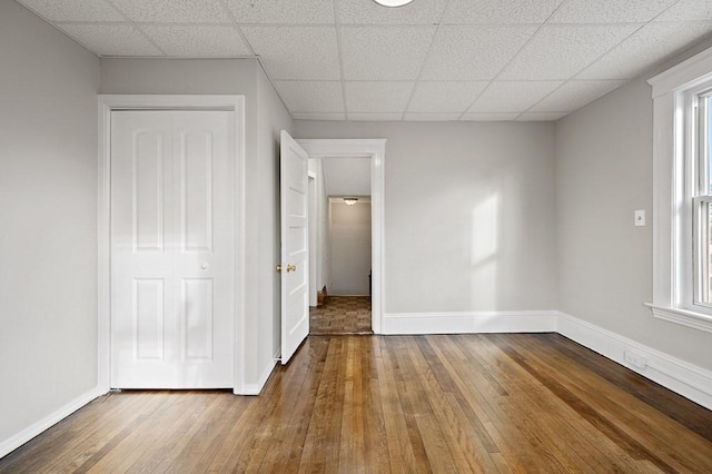 unfurnished bedroom featuring multiple windows, a closet, and wood-type flooring