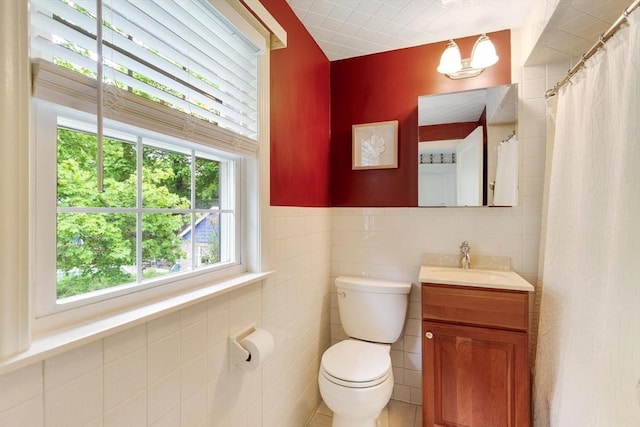 bathroom featuring tile walls, toilet, and vanity