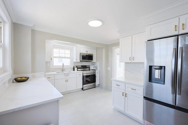 21 Trefton Dr, Braintree, MA 02184 - kitchen with stainless steel appliances, a sink, ornamental molding, white cabinetry, and light stone countertops