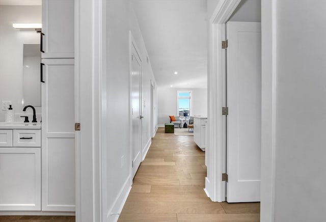 hall featuring light hardwood / wood-style floors and sink