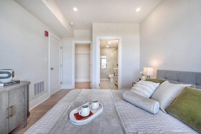 bedroom with light wood-type flooring, a closet, and connected bathroom