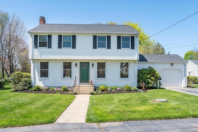 colonial home with a shingled roof, a front lawn, brick siding, a garage, and a chimney