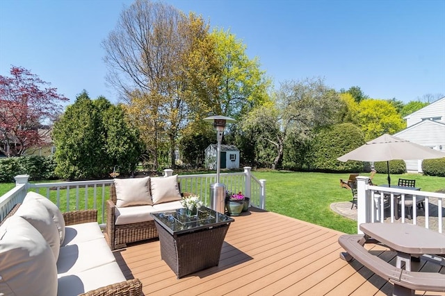 wooden terrace with an outdoor living space, an outdoor structure, a yard, and a storage unit
