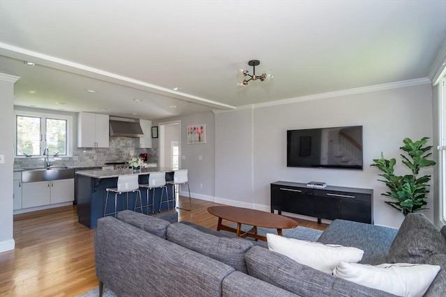 living room featuring baseboards, an inviting chandelier, and light wood-style flooring
