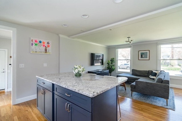 kitchen featuring baseboards, a kitchen island, light wood-style flooring, and open floor plan