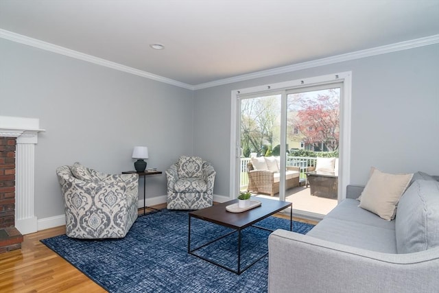 living room featuring crown molding, baseboards, a fireplace, and wood finished floors