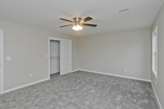 unfurnished bedroom with ceiling fan, light colored carpet, and a closet