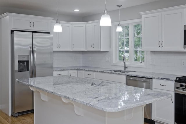 kitchen featuring white cabinets, a breakfast bar, sink, and appliances with stainless steel finishes