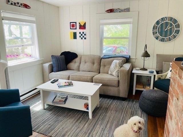 living area with baseboard heating and wood finished floors