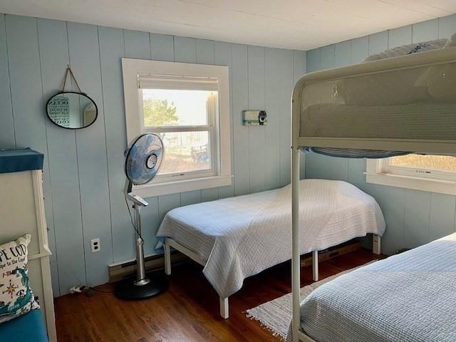 bedroom with multiple windows and wood finished floors