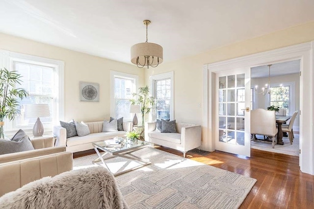 living room featuring hardwood / wood-style floors, a wealth of natural light, and an inviting chandelier